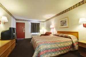 a hotel room with a bed and a flat screen tv at Americas Best Value Inn & Suites Macon in Macon