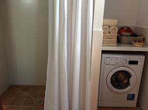 a white shower curtain next to a washing machine at CAN TONI DEN MESTRE in Cala Saona