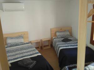 dwa łóżka w małym pokoju z dwoma uncjami w obiekcie Casa del Pintor w mieście Horta de San Joan