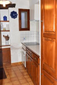 a kitchen with wooden cabinets and a counter top at Maison CÉDÉJI in Baudinard