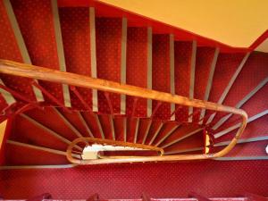 - un escalier dans une pièce dotée d'un plafond rouge dans l'établissement Le Richelieu Bacchus, à Fontainebleau