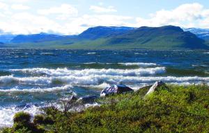 a large body of water with mountains in the background at Guesthouse Haltinmaa in Kilpisjärvi