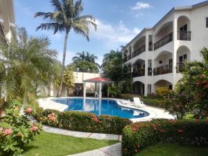 a resort with a swimming pool in front of a building at Apartamento en Las Terrenas in Las Terrenas
