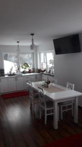 a white kitchen with a white table and chairs at Pension Casa Contelui in Râşnov