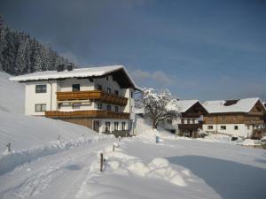 a snow covered building in front of a ski resort at Bahlerhof - Luxner Annelies in Ried im Zillertal