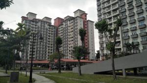 a group of tall buildings with palm trees in front at Apartment Next to Unifi Arena Axiata, Stadium Bukit Jalil in Kuala Lumpur