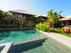 a swimming pool in front of a house at BaanSuk Sukhothai Resort in Sukhothai