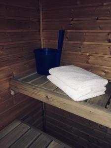 a sauna with a stack of towels on a shelf at Hotel Yöpuu in Kemi