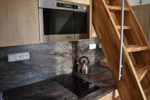 a tea kettle is sitting on a stove in a kitchen at Apartma FARA in Loučná nad Desnou