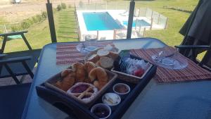 una bandeja de comida en una mesa junto a una piscina en Altas Tierras de Ventania en Sierra de la Ventana