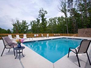 a swimming pool with chairs and a vase of flowers at Tucked Away Cabin in Pigeon Forge