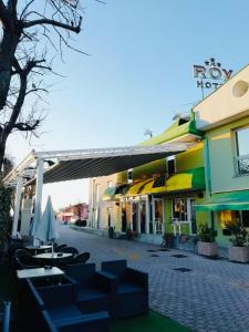 un grupo de mesas y sillas frente a un edificio en B&B Hotel Roy, en Silea