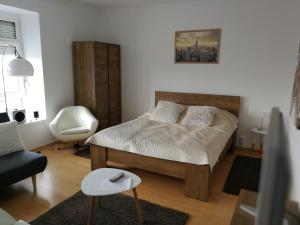 1 dormitorio pequeño con 1 cama y 1 silla en Ida Apartman, en Miskolc