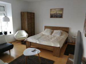 - une petite chambre avec un lit et une chaise dans l'établissement Ida Apartman, à Miskolc