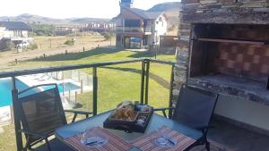 a table and chairs on a balcony with a view at Altas Tierras de Ventania in Sierra de la Ventana