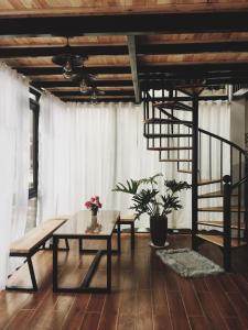 a living room with a table and a bench at Bách Xanh House. Nhà Gác Lửng in Vĩnh Phúc