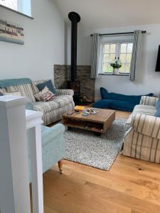 a living room with two couches and a coffee table at Bossiney Cove Cottage in Tintagel