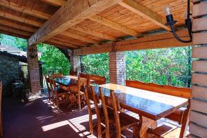 a porch with wooden tables and chairs on a patio at Agriturismo Il Picchio Verde in Licciana Nardi