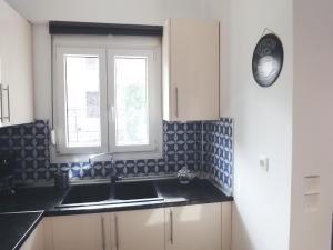 una cucina con lavandino e finestra di Polychrono Nikos Apartment a Polykhrono