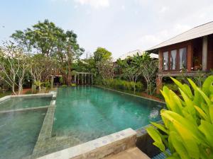 a large pool of water in front of a house at BaanSuk Sukhothai Resort in Sukhothai