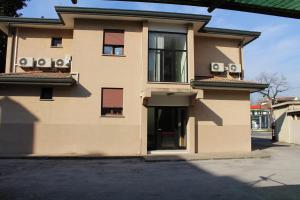 a tan building with two balconies and two windows at Hotel Colombo in Marghera