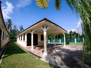 a building with a pavilion in a yard at Desa Tunjung Homestay in Kangar