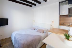 a white bedroom with a bed and a table at ★ LE CÔTÉ GARONNE ★ HYPERCENTRE ★ NETFLIX ★ in Toulouse