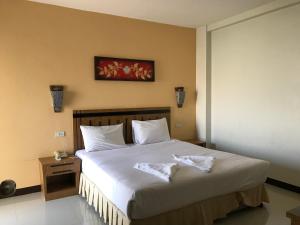 a bedroom with a large bed with white sheets at UD Residence in Udon Thani