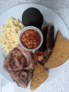 a plate of food with sausage beans and dips at Lion House Bed & Breakfast with Restaurant in Combe Martin