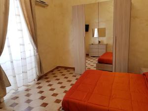 a bedroom with an orange bed and a mirror at Duomo Central Loft in Naples