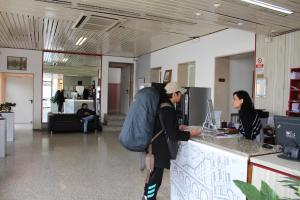 a man and a woman standing at a counter with a computer at Hotel Colombo in Marghera