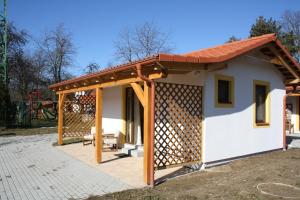 a house with a wooden roof and a patio at Penzion Kaminek in Nové Hrady
