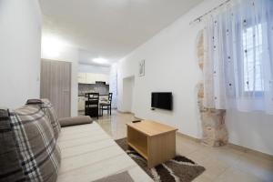 a living room with a couch and a tv on a wall at Apartment Elena in Bale