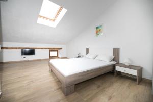a white bedroom with a bed and a television at Apartment Elena in Bale