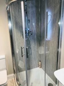 a shower with a glass door in a bathroom at The Maples 26 Wellingtonia Court in Inverness