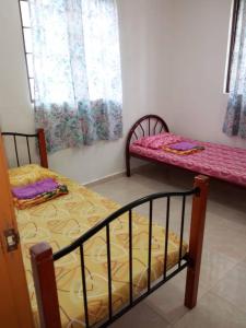 a bedroom with two bunk beds and a window at Desa Tunjung Homestay in Kangar