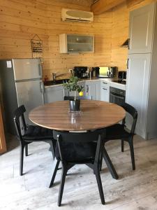 uma cozinha com uma mesa de madeira e um frigorífico em Gîte pour 4 personnes em Saint-Martin-du-Fouilloux