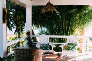 a porch with two white chairs and a table at Casas Serenas in Estreito da Calheta