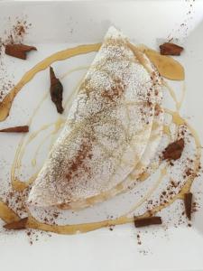 a stack of pancakes with powdered sugar on a plate at Aroeiraecocasa in Morro de São Paulo +20 photos