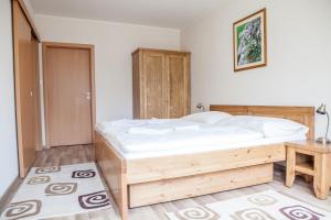 a bedroom with a wooden bed in a room at Apartmany Belianky in Vysoke Tatry - Tatranska Lomnica.