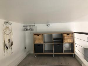 クレルモン・フェランにある2 Lofts Cosy de cachet idéalement situés au Centre Ville de Clermont-Ferrandの籐のバスケットが入った棚付きの部屋