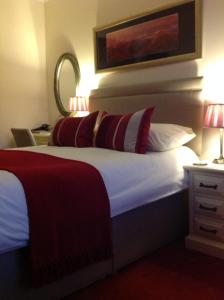 a hotel room with a bed with red and white pillows at Bed and Breakfast at 4 in Thurso