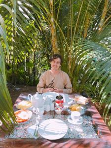 a man sitting at a table with a plate of food at Home Away Ella in Ella