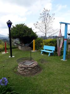 un parc avec une aire de jeux et un banc bleu dans l'établissement Finca Cardonales, à Salento