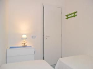Habitación con armario, cama y lámpara. en Casa vacanze Dune sul mare, en San Pietro in Bevagna