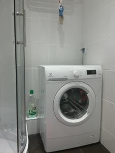 a washer and dryer in a small room at Pomaranczowa Apartment in Szczecin