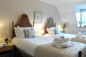 a bedroom with two beds with stuffed animals on them at Knightcote Farm Cottages in Gaydon