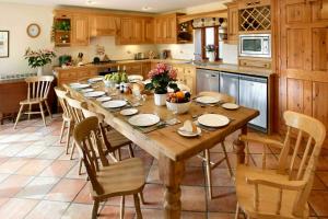 a kitchen with a large wooden table and chairs at Knightcote Farm Cottages in Gaydon