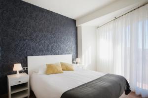 Łóżko lub łóżka w pokoju w obiekcie Hotel El Cid