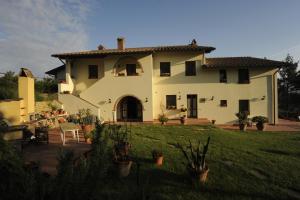 a large white house with a yard with plants at Agriturismo SANTA BARBARA in San Miniato